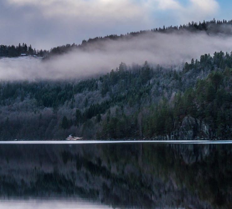 A small farm on top of the mountain suddenly appeared for a few seconds through the heavy fog covering the mountains around the lake Ytre Øydnavatnet in the south of Norway.