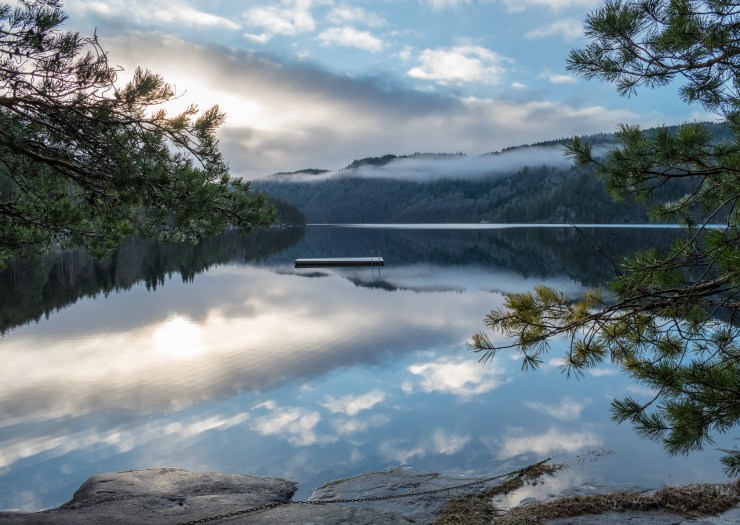 The small ripples in the water adds some movement to this photo and makes the reflection quite unique. Norway Ytre Øydnavatnet mountains fog clouds forest