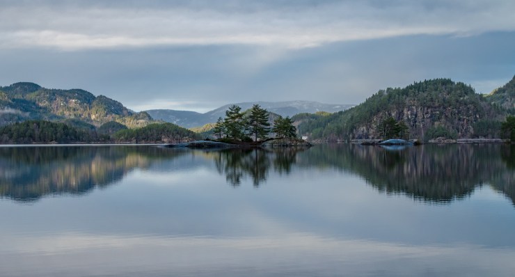 Water reflection of forest covered mountains around the lake called Ytre Øydnavatnet in the south of Norway.